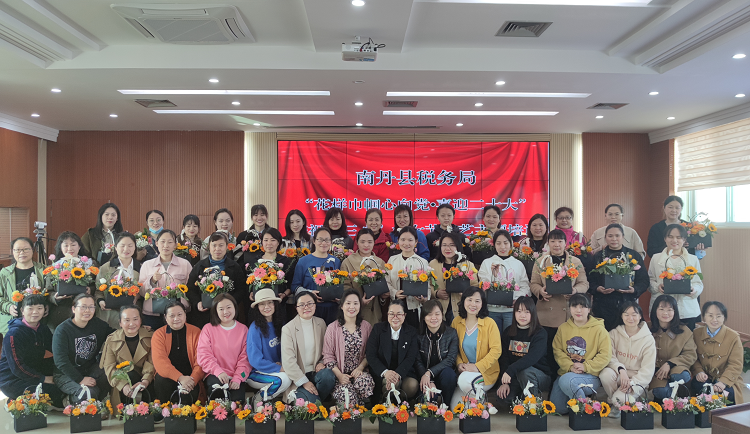 4.县税务局插花班学员们拿着自己亲手做的花篮拍集体照.png